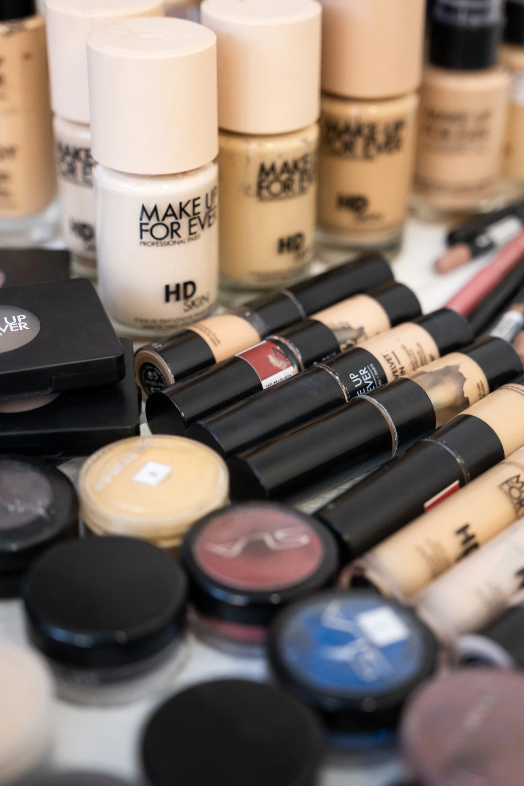 Тональные основы, помады и пудра Make Up For Ever на столе