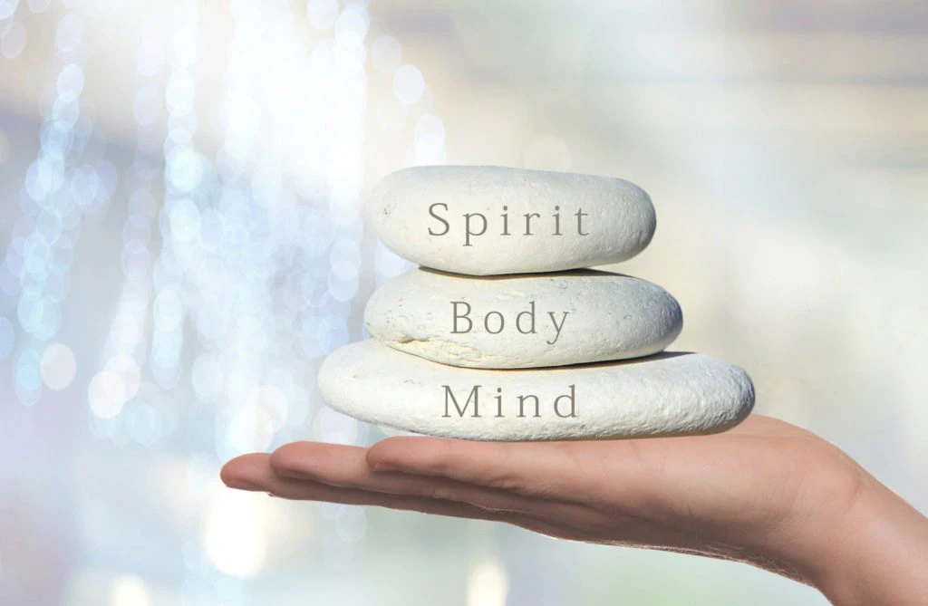 Delne sukrauti akmenys su užrašais Spirit, Body, Mind